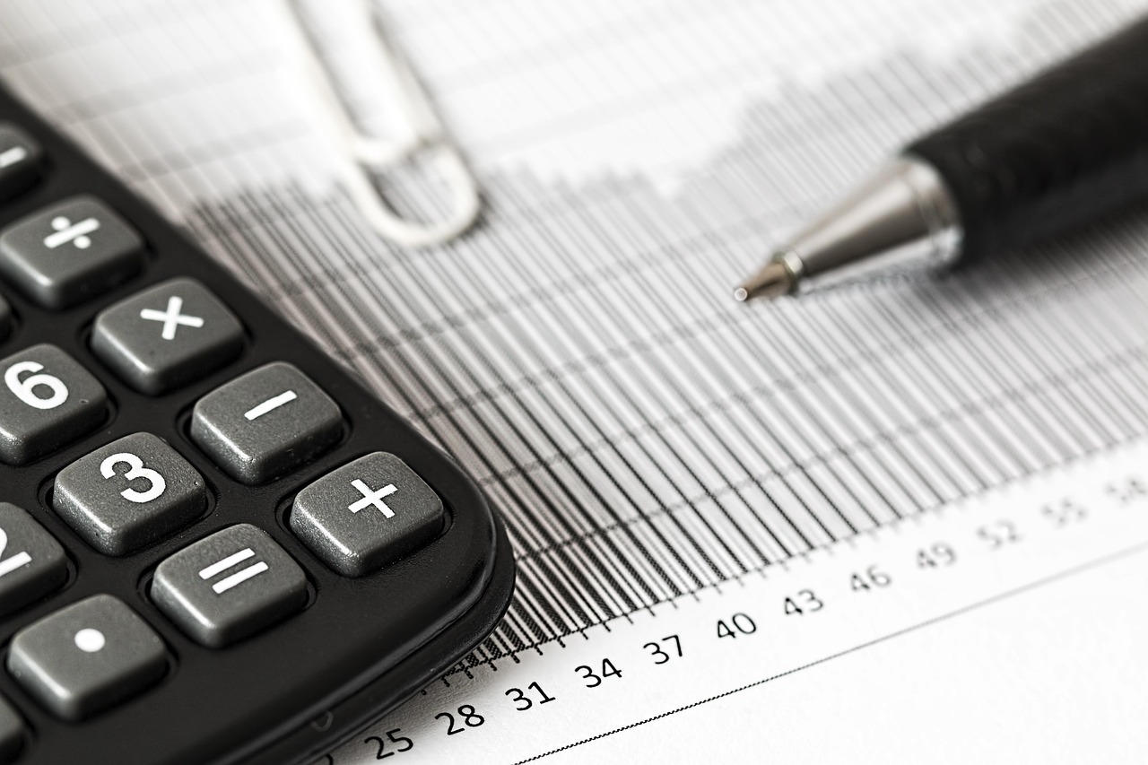 Photo: property management for rentals, rent collection, utilities and common expenses bills, spreadsheet Excel, landlord paperwork, calculator on desk